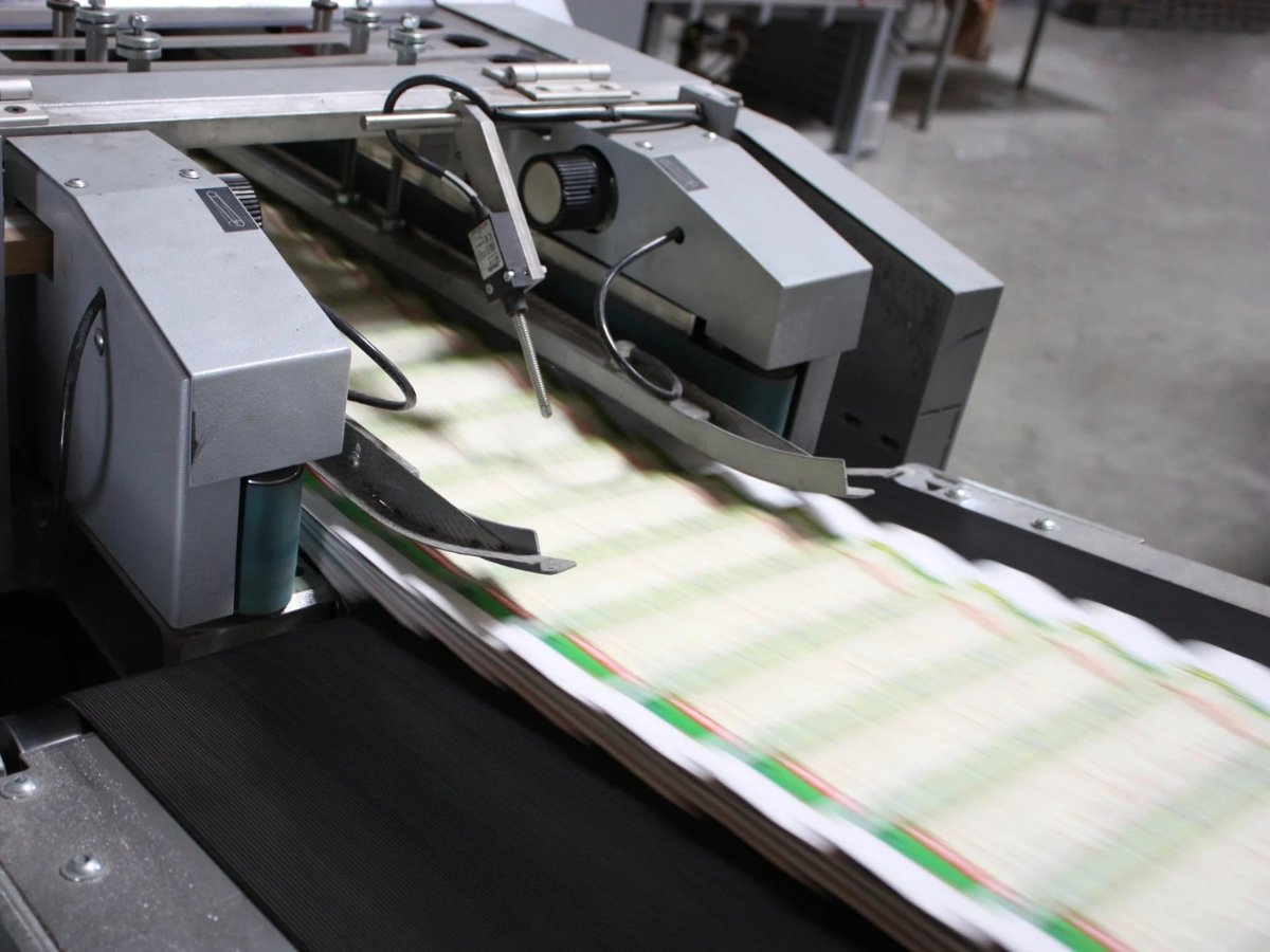 Paper products moving along a conveyor belt on a paper processing line